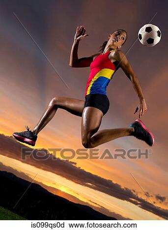 Female footballer in mid air against sunset View Large Photo Image Stock Image - Female footballer in mid air against sunset. Fotosearch