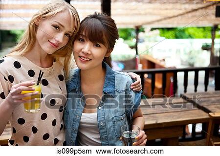 Female friends posing with soft drinks View Large Photo Image Picture - Female friends posing with soft drinks. Fotosearch