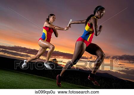 Female relay racers passing baton View Large Photo Image Stock Photograph - Female relay racers passing baton. Fotosearch