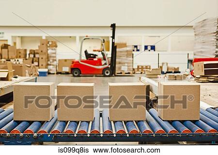 Stock Photograph - Four cardboard boxes on conveyor belt. Fotosearch
