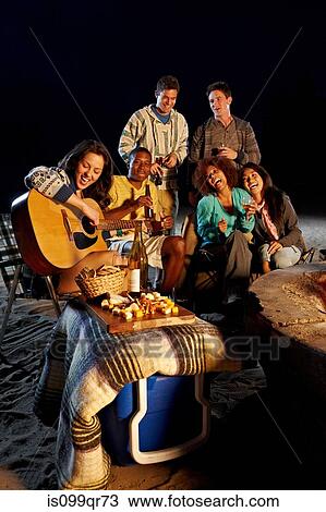 Friends having beach party at night View Large Photo Image Stock Image - Friends having beach party at night. Fotosearch