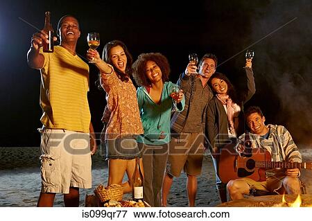 Friends having beach party at night View Large Photo Image Stock Photo - Friends having beach party at night. Fotosearch