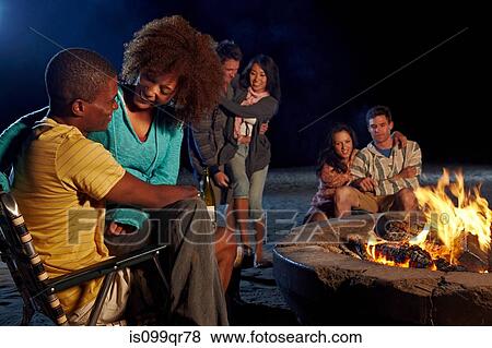 Friends having beach party at night View Large Photo Image Stock Photo - Friends having beach party at night. Fotosearch