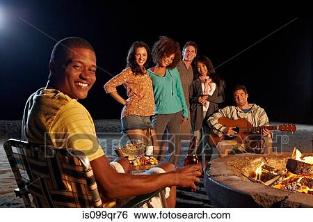 Friends having beach party at night View Large Photo Image Stock Photograph - Friends having beach party at night. Fotosearch