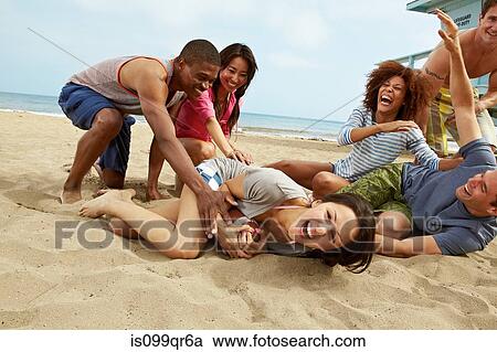 Friends on beach playing rugby View Large Photo Image Stock Image - Friends on beach playing rugby. Fotosearch