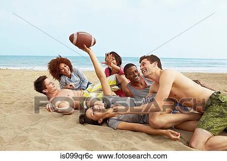 Friends on beach playing rugby View Large Photo Image Stock Image - Friends on beach playing rugby. Fotosearch