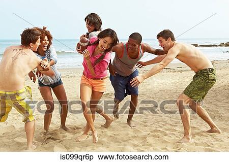 Friends on beach playing rugby View Large Photo Image Stock Photography - Friends on beach playing rugby. Fotosearch