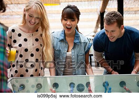Friends playing table football View Large Photo Image Stock Image - Friends playing table football. Fotosearch