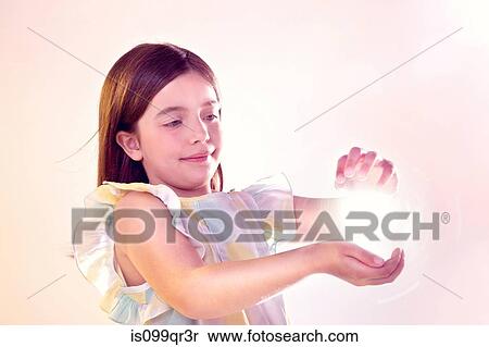Girl holding a ball of light View Large Photo Image Stock Photography - Girl holding a ball of light. Fotosearch