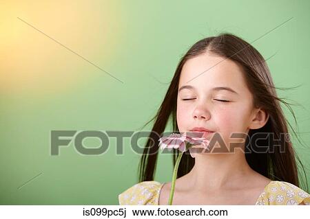 Stock Image - Girl sniffing flower. Fotosearch