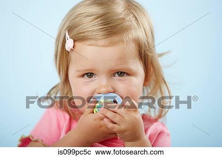 Stock Image - Girl with pacifier in mouth. Fotosearch