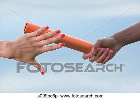 Hands of female relay athletes passing a baton, close up View Large Photo Image Stock Photography - Hands of female relay athletes passing a baton, close up. Fotosearch