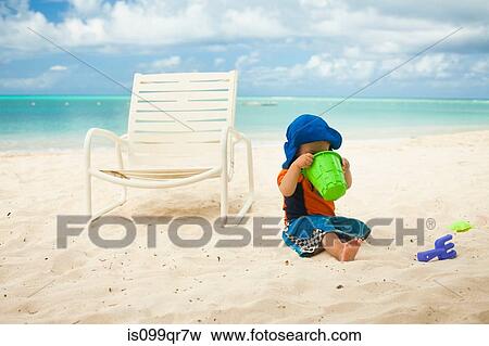 Little boy at the beach, looking into a bucket View Large Photo Image Stock Photo - Little boy at the beach, looking into a bucket. Fotosearch