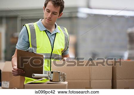 Man checking cardboard boxes View Large Photo Image Stock Image - Man checking cardboard boxes. Fotosearch