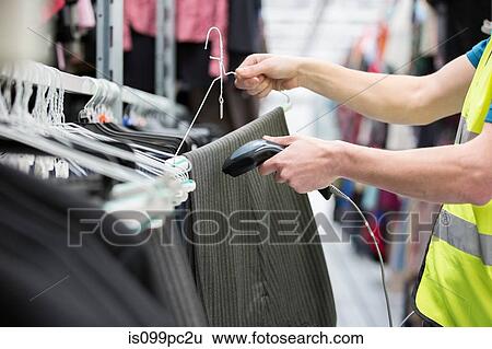 Man checking pair of trousers in warehouse View Large Photo Image Stock Photograph - Man checking pair of trousers in warehouse. Fotosearch