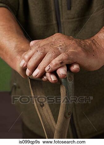 Man leaning with hands on wooden handle View Large Photo Image Stock Photograph - Man leaning with hands on wooden handle. Fotosearch