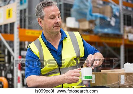 Man on tea break in warehouse View Large Photo Image Stock Image - Man on tea break in warehouse. Fotosearch