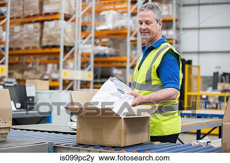Man packing clothing into cardboard box View Large Photo Image Stock Photo - Man packing clothing into cardboard box. Fotosearch