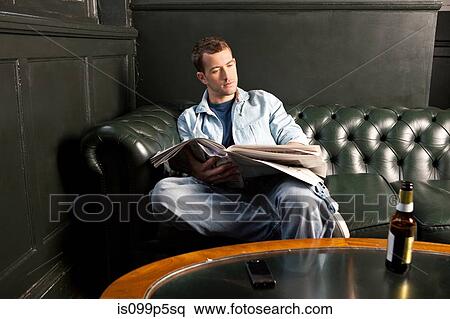 Stock Photography - Man reading newspaper in pub. Fotosearch