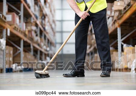 Man sweeping warehouse floor with broom View Large Photo Image Picture - Man sweeping warehouse floor with broom. Fotosearch