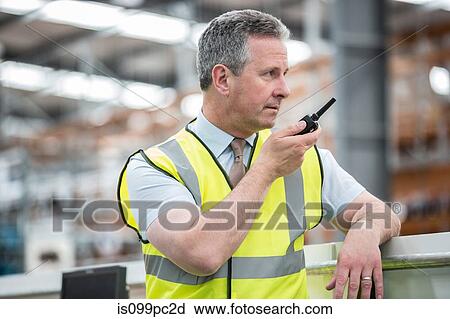 Man using walkie talkie in warehouse View Large Photo Image Stock Image - Man using walkie talkie in warehouse. Fotosearch