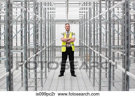 Man with arms folded in empty warehouse, portrait View Large Photo Image Stock Photography - Man with arms folded in empty warehouse, portrait. Fotosearch
