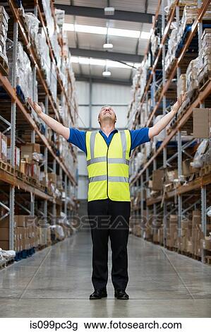 Man with arms raised in warehouse, portrait View Large Photo Image Stock Image - Man with arms raised in warehouse, portrait. Fotosearch