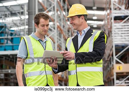 Men in warehouse using digital tablet View Large Photo Image Stock Image - Men in warehouse using digital tablet. Fotosearch