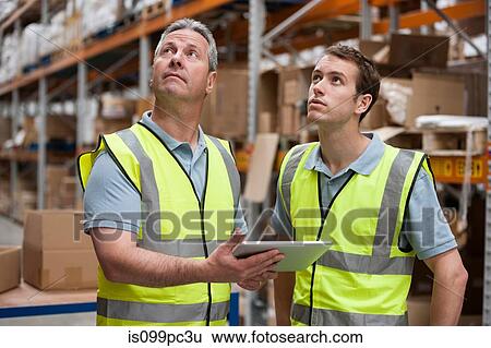 Men in warehouse using digital tablet View Large Photo Image Stock Photograph - Men in warehouse using digital tablet. Fotosearch