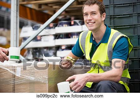 Stock Image - Men on lunch break in warehouse. Fotosearch