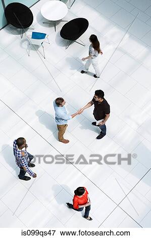 Stock Photo - Men shaking hands on concourse. Fotosearch