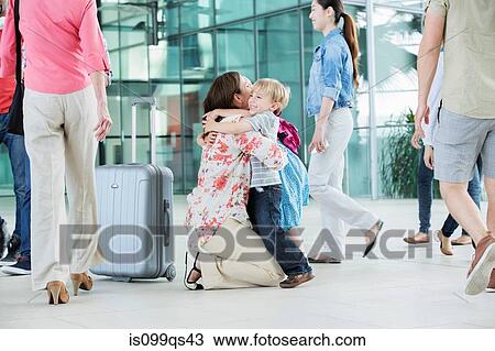 Mother hugging children at airport View Large Photo Image Stock Image - Mother hugging children at airport. Fotosearch