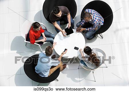 Overhead view of colleagues in meeting View Large Photo Image Picture - Overhead view of colleagues in meeting. Fotosearch