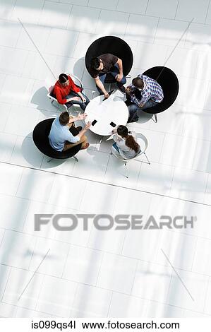 Overhead view of colleagues in meeting View Large Photo Image Stock Image - Overhead view of colleagues in meeting. Fotosearch