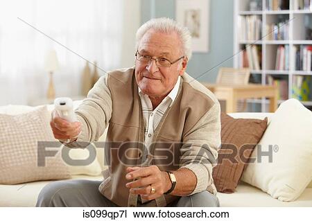 Stock Image - Senior man changing channels. Fotosearch