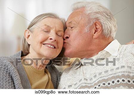 Picture - Senior man kissing senior woman on cheek. Fotosearch