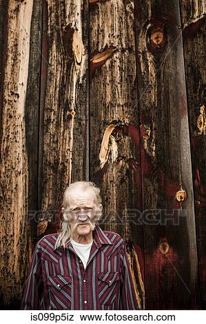 Stock Photo - Senior man outside barn, portrait. Fotosearch