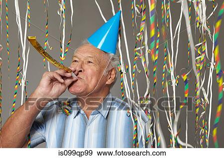 Senior man with party blower and streamers View Large Photo Image Stock Photo - Senior man with party blower and streamers. Fotosearch