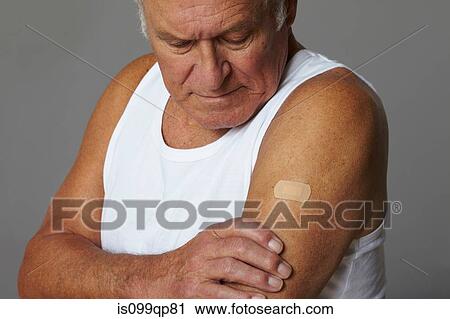 Stock Image - Senior man with plaster on arm. Fotosearch