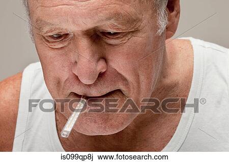 Stock Image - Senior man with thermometer in mouth. Fotosearch
