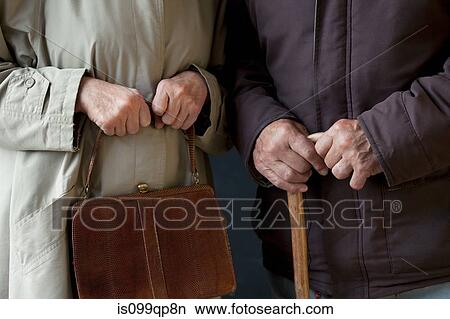 Picture - Senior man with walking stick, senior woman with handbag. Fotosearch