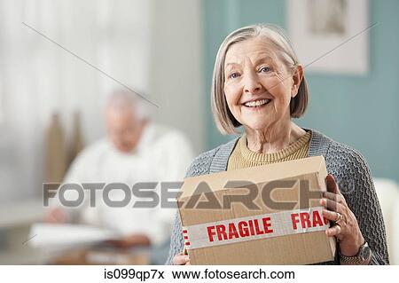 Senior woman holding parcel, portrait View Large Photo Image Stock Photo - Senior woman holding parcel, portrait. Fotosearch