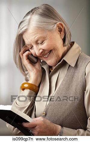 Senior woman holding picture frame on the phone View Large Photo Image Picture - Senior woman holding picture frame on the phone. Fotosearch