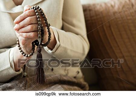 Senior woman holding rosary beads View Large Photo Image Stock Image - Senior woman holding rosary beads. Fotosearch