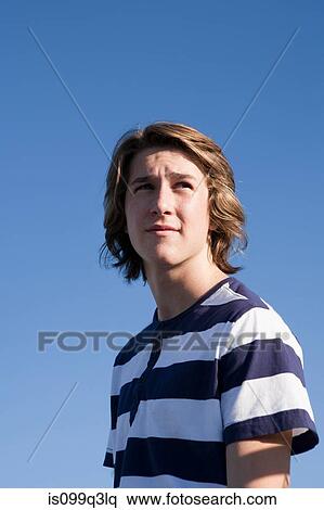 Teenage boy wearing blue and white striped t shirt against blue sky, portrait View Large Photo Image Stock Photography - Teenage boy wearing blue and white striped t shirt against blue sky, portrait. Fotosearch