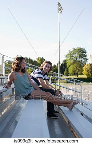 Teenage couple sitting on bleachers View Large Photo Image Stock Photograph - Teenage couple sitting on bleachers. Fotosearch