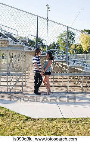 Teenage couple standing by bleachers View Large Photo Image Stock Photograph - Teenage couple standing by bleachers. Fotosearch