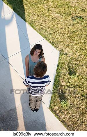 Stock Photo - Teenage couple standing on path from above. Fotosearch