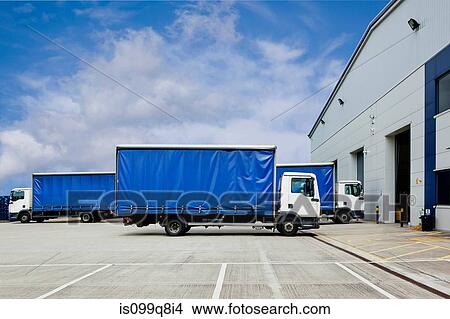 Trucks parked outside distribution warehouse View Large Photo Image Picture - Trucks parked outside distribution warehouse. Fotosearch