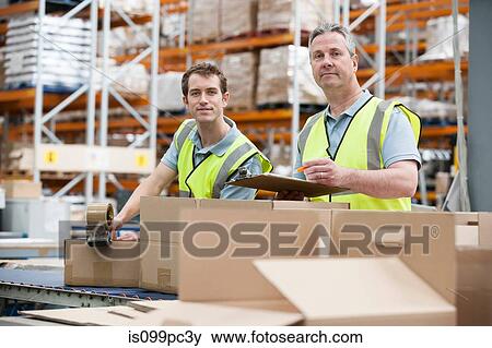 Two men checking stock in warehouse View Large Photo Image Stock Photo - Two men checking stock in warehouse. Fotosearch